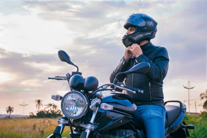 jeune motard qui met son casque