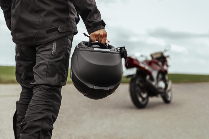 homme avec un casque de moto noir à la main 