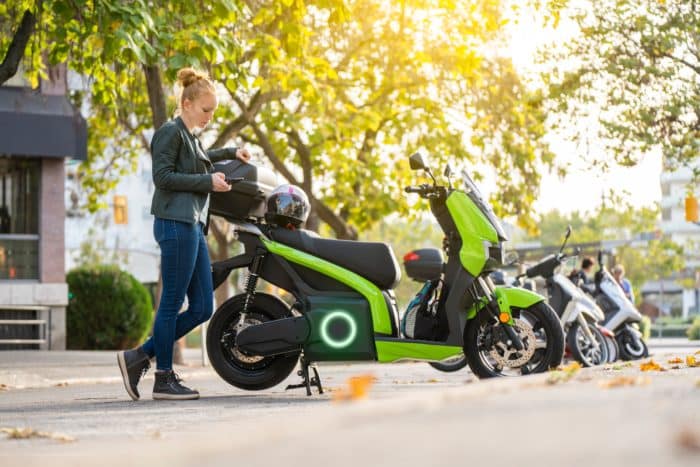 Femme avec un scooter électrique vert