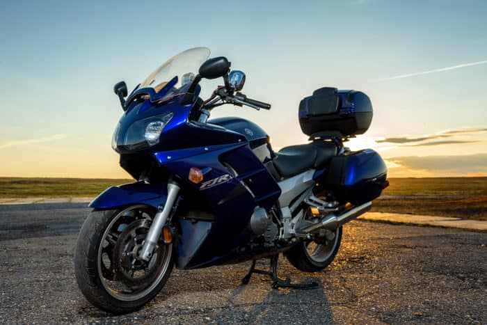 yamaha fjr 1300 bleue sur une route avec un couché de soleil